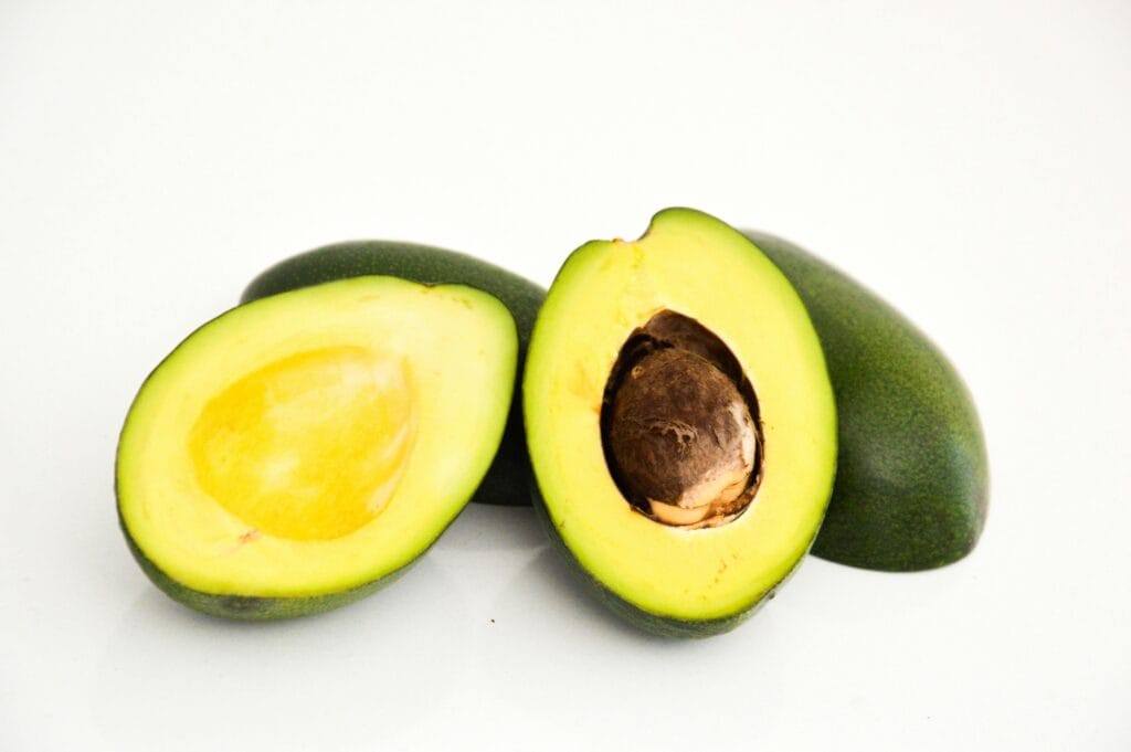 Close-up of fresh avocado halves showcasing vibrant green flesh and seed.